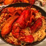 lobster in spaghetti in a black pan