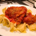 chicken thigh over buttered egg noodles with tomato sauce