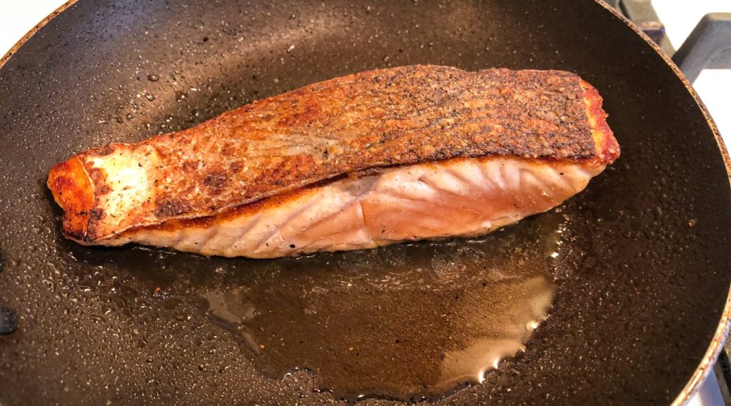 Seared salmon filet resting on pan